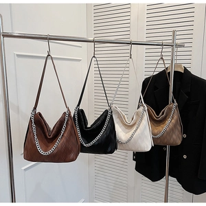 Close-up of pleated leather shoulder bags in four colors with decorative silver chains