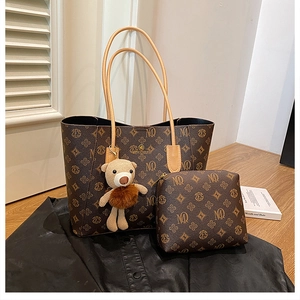 Detail of dark brown monogram tote bag with matching pouch and knit bear charm
