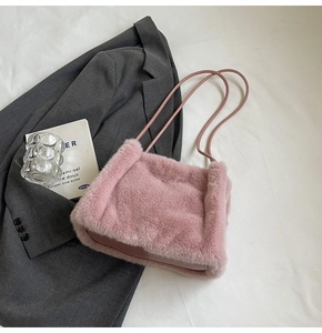 Detailed close-up of soft pink faux fur texture on a stylish autumn-winter shoulder bag