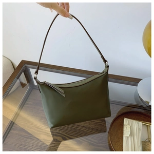 Detail view of military green minimalist shoulder bag with brown strap and zip closure