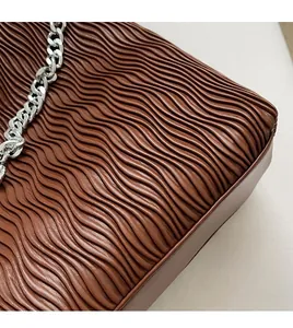 Detailed view of the brown ruched texture fabric and thick silver chain on the tote bag