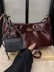 Retro burgundy shoulder bag with metallic clasp and mini pouch on stone surface