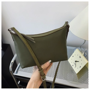Detail view of olive green shoulder bag with adjustable strap and silver buckle