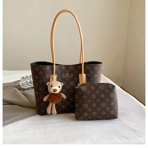 Detail of vintage brown monogram tote bag set with matching pouch and bear charm