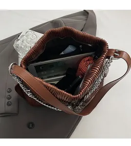 Top view of brown pleated shoulder bag showing spacious interior with tablet and umbrella
