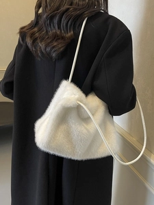 White faux fur shoulder bag for women styled with a black coat for winter look