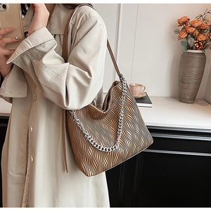 Detail of khaki pleated bucket bag featuring silver chain and soft PU leather texture