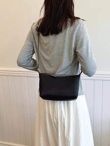 Minimalist black crescent crossbody bag for women with adjustable silver buckle strap