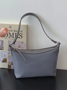 Chic grey-blue shoulder bag with brown leather handles and silver metal zipper
