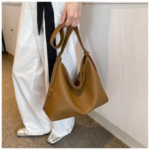 Brown lychee leather hobo shoulder bag with adjustable strap shown on model for daily use