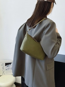 Minimalist olive green crescent shoulder bag in matte nylon styled with a grey blazer