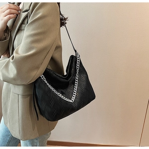 Detail of black wave texture shoulder bag with chunky silver chain and cloud-like pleats