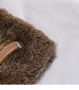 Detail shot of plush brown faux fur bag showing the smooth zipper and leather trim