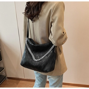 Detail of black pleated PU shoulder bag with silver chain strap and large capacity