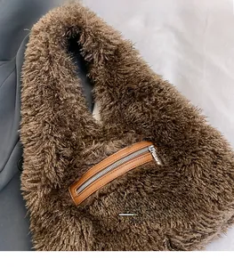 Detailed macro view of brown faux fur texture and leather zipper pocket on the handbag