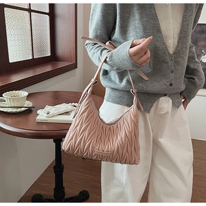 Close-up of pink matelassé textured underarm bag with delicate adjustable strap