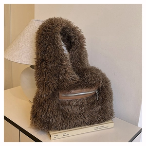 Detail of dark brown faux fur tote bag with a leather zipper pocket on a studio table