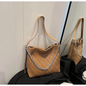 Detail of brown pleated texture and silver metal chain on large capacity tote bag