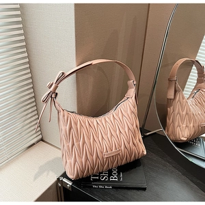 Detail of pink matelassé shoulder bag with delicate bow knot and metallic zipper