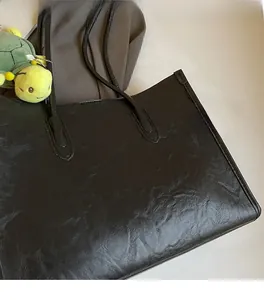 Dettaglio ravvicinato della borsa tote nera che mostra la trama increspata e la pelle PU