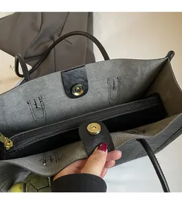 Dettaglio della grande borsa tote in pelle nera con chiusura magnetica e tasca con cerniera