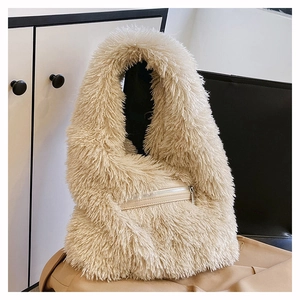 Detail of soft beige faux fur shoulder bag featuring a front synthetic leather zipper pocket