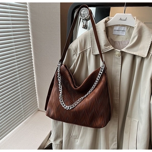 Macro shot of brown wrinkled leather texture and silver chain on a Hobo bag