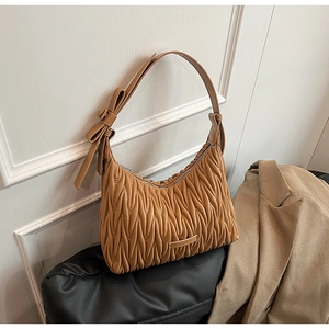 Close-up of brown pleated shoulder bag with Matelassé texture and bow detail