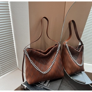 Detail view of dark brown pleated texture tote bag with silver chain strap decoration