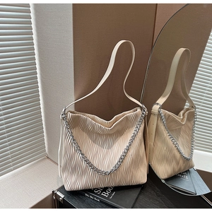 Detail of off-white pleated shoulder bag with silver chain and vertical wavy texture