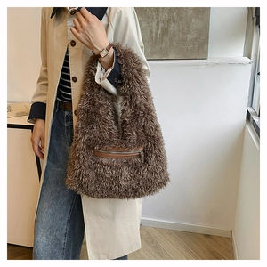 Detail of fluffy brown faux fur shoulder bag featuring a zippered front leather pocket