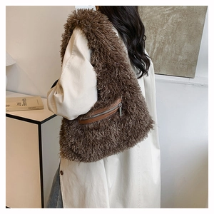 Detail of plush brown shoulder bag with faux fur texture and side zipper on model