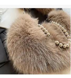 Détail du sac bandoulière en peluche marron avec poignée perlée et texture douce en fourrure