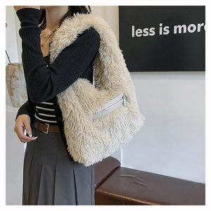 Detail of plush beige shoulder bag featuring a silver metal front zipper pocket
