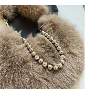 Détail du sac à bandoulière en fausse fourrure marron avec chaîne à boules métalliques