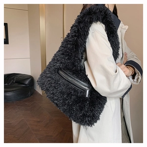 Close-up of black fuzzy tote bag featuring silver metal zipper detail and plush texture