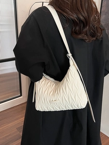 White matelassé pleated underarm shoulder bag with elegant bow design for women