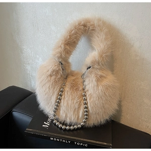 Détail du sac beige en fausse fourrure douce avec chaîne décorative à billes argentées