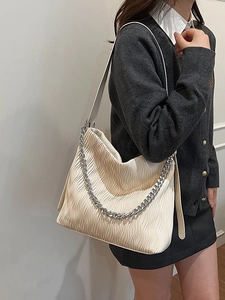 Off-white pleated tote bag with silver chain strap shown as a stylish crossbody bag