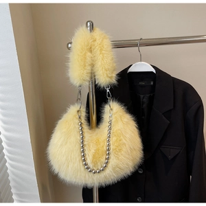 Détail d'un sac hobo en fausse fourrure jaune vif avec bandoulière en chaîne argentée