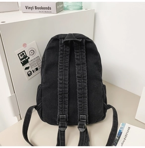Detail view of the black washed canvas backpack back with adjustable shoulder straps