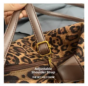 Detail of leopard print tote bag showing adjustable brown leather strap and metal buckle