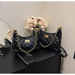 Dettaglio borsa hobo in pelle trapuntata nera con catena dorata e chiusura a girello