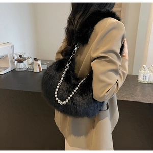 Détail du sac croissant en fausse fourrure noire avec chaîne à billes argentée et bandoulière