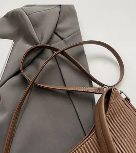 Close-up of brown pleated leather strap showing soft texture and fine stripe pattern