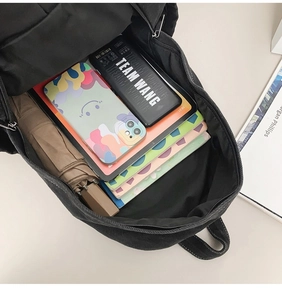 Interior view showing large capacity of the black denim backpack for books and gadgets