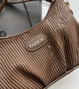 Detailed macro view of the brown pleated leather texture and Fashion label on the handbag