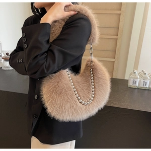 Détail d'un sac demi-lune en fausse fourrure beige avec une chaîne à billes argentée