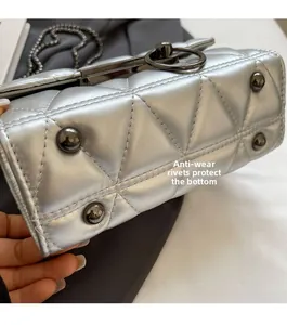 Detail view of silver quilted crossbody bag featuring protective bottom metal rivets