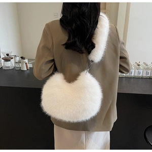 Détail du sac à épaule en peluche blanche avec crochets métalliques argentés sur la bandoulière